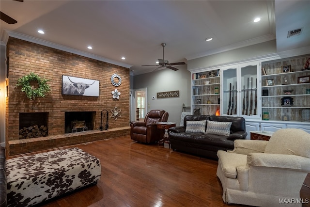 living room with brick wall, crown molding, dark wood-type flooring, ceiling fan, and a brick fireplace