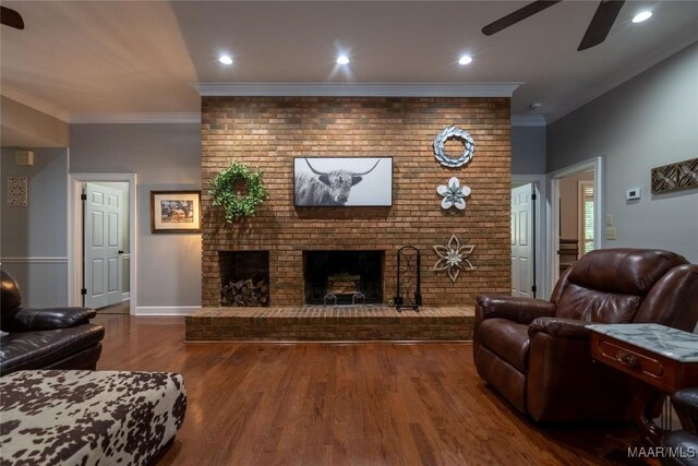 living room with ornamental molding, dark hardwood / wood-style floors, brick wall, a fireplace, and ceiling fan