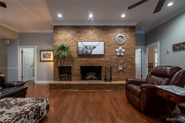 living room with crown molding, a fireplace, recessed lighting, a ceiling fan, and wood finished floors