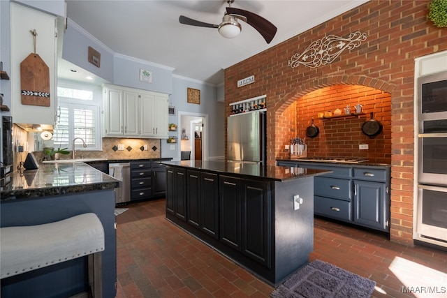 kitchen featuring tasteful backsplash, brick wall, dark stone countertops, and stainless steel appliances