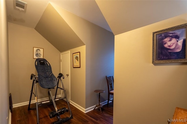 workout area featuring lofted ceiling, visible vents, dark wood finished floors, and baseboards