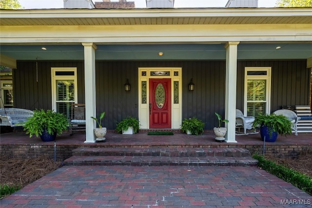 entrance to property with a porch and board and batten siding