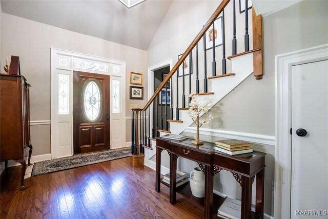 foyer entrance with vaulted ceiling and dark hardwood / wood-style floors