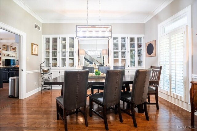 dining area with dark hardwood / wood-style floors, a healthy amount of sunlight, and ornamental molding