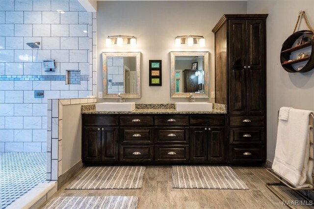 bathroom featuring a shower, tile walls, vanity, and wood-type flooring