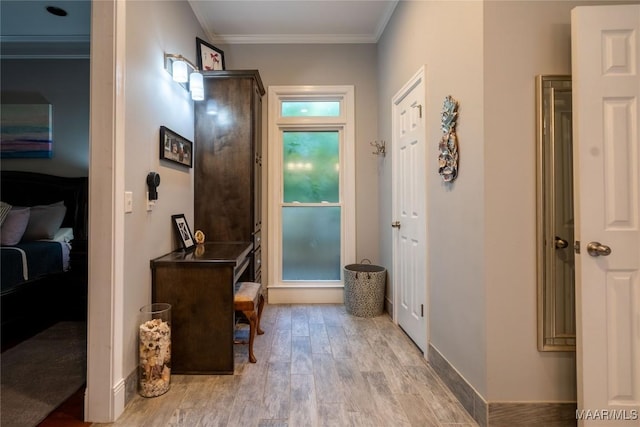 interior space featuring crown molding, baseboards, and wood finished floors