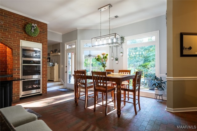 dining area with ornamental molding, brick wall, and a chandelier