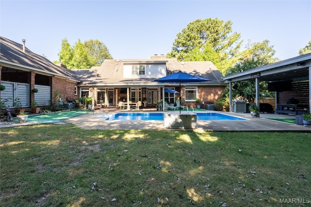 rear view of property with central AC unit, a patio, and a yard