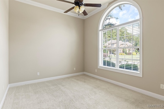 unfurnished room with a wealth of natural light, ornamental molding, light colored carpet, and ceiling fan