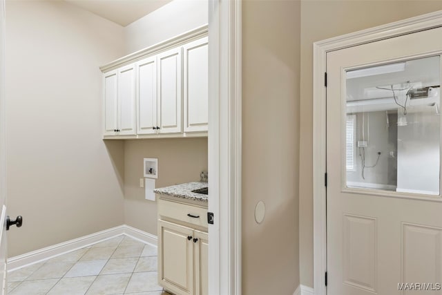 laundry area with light tile patterned floors, washer hookup, and cabinets