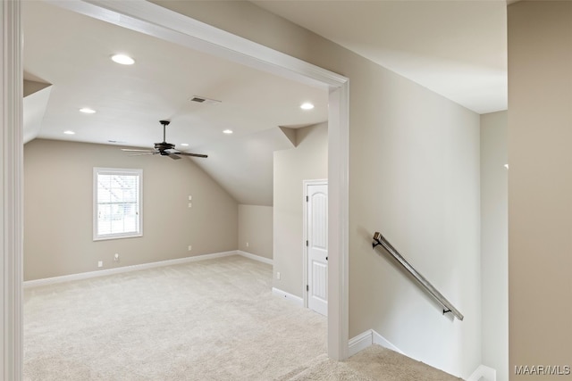 additional living space featuring ceiling fan, vaulted ceiling, and light colored carpet