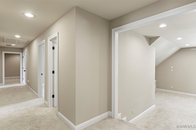 hall featuring light colored carpet and vaulted ceiling