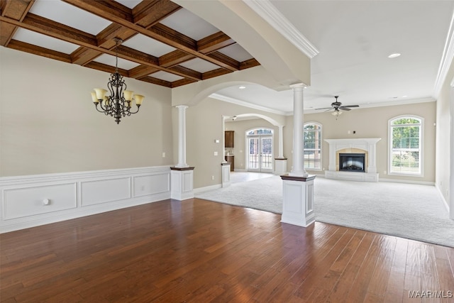 unfurnished living room featuring carpet floors, crown molding, ceiling fan with notable chandelier, and coffered ceiling