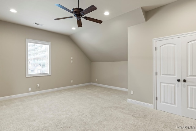 additional living space with light colored carpet, vaulted ceiling, and ceiling fan