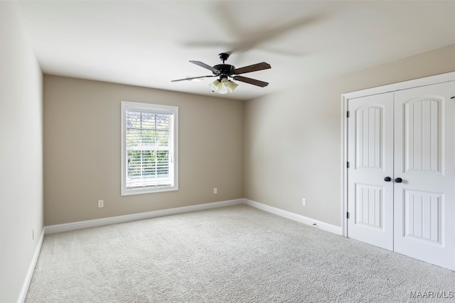 unfurnished bedroom with ceiling fan, carpet, and a closet