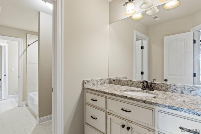 bathroom with tile patterned flooring, tiled shower / bath combo, and vanity