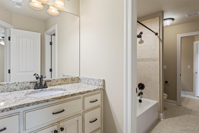 full bathroom featuring tiled shower / bath combo, tile patterned flooring, toilet, and vanity