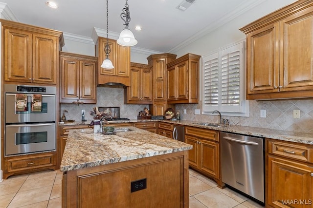 kitchen featuring appliances with stainless steel finishes, brown cabinets, a sink, and visible vents