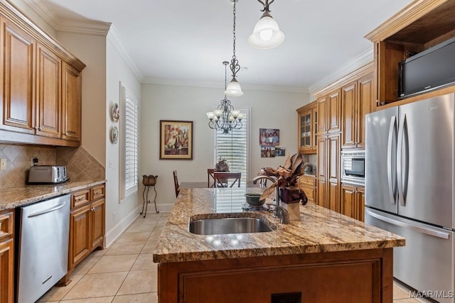 kitchen with appliances with stainless steel finishes, a kitchen island with sink, brown cabinets, and a sink