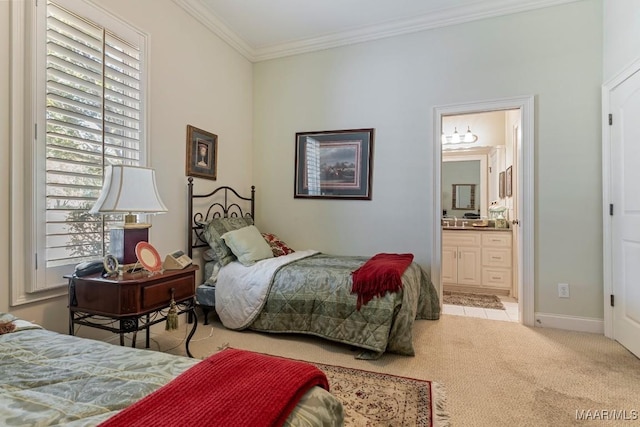 bedroom with ornamental molding, baseboards, light colored carpet, and ensuite bath