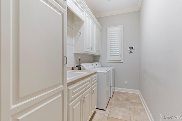 washroom with crown molding, washing machine and clothes dryer, light tile patterned floors, cabinet space, and baseboards