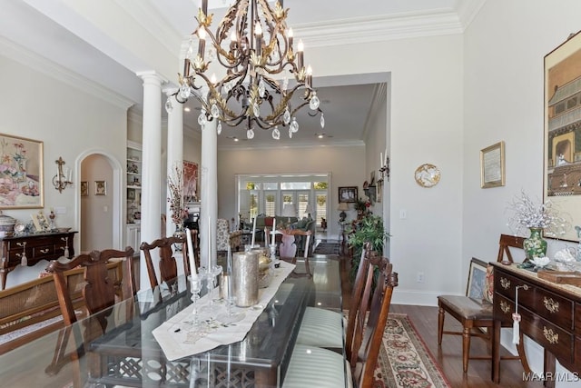 dining room with arched walkways, baseboards, wood finished floors, and crown molding