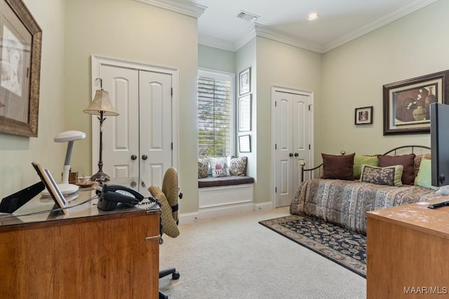 bedroom featuring light carpet, baseboards, visible vents, ornamental molding, and two closets