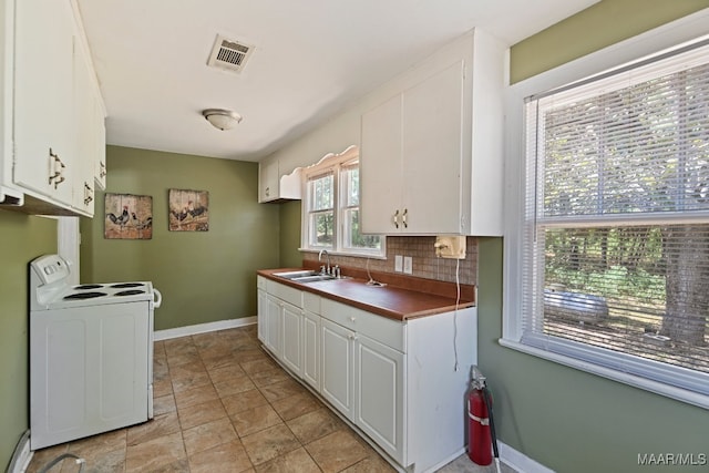 kitchen with sink, white cabinetry, decorative backsplash, electric stove, and light tile patterned floors