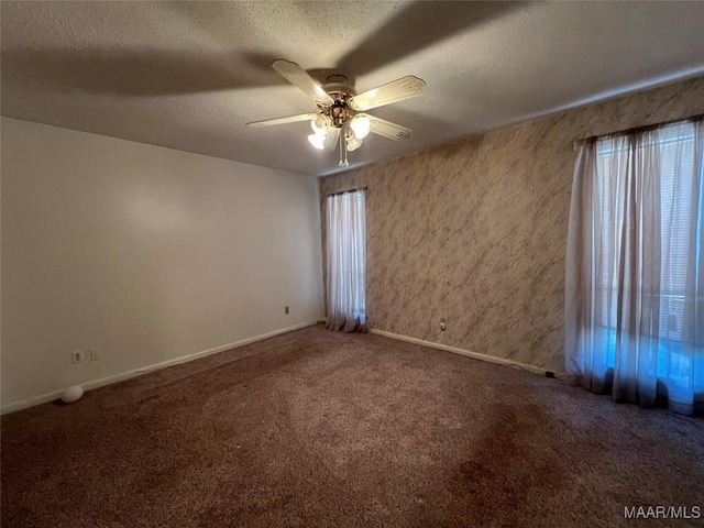 carpeted spare room featuring ceiling fan, plenty of natural light, and a textured ceiling