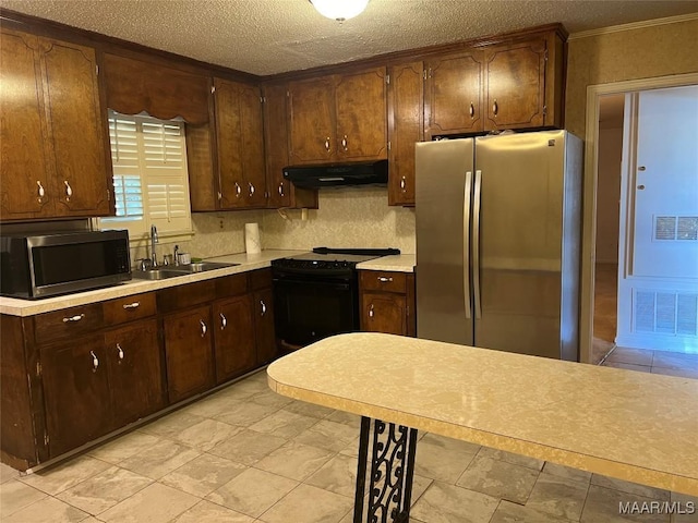 kitchen featuring tasteful backsplash, sink, stainless steel appliances, and a textured ceiling