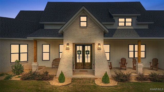 view of front of house with a yard and french doors