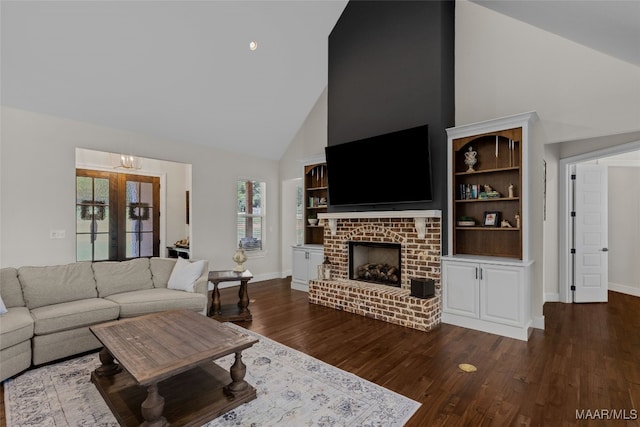 living room featuring dark hardwood / wood-style floors, high vaulted ceiling, and a brick fireplace