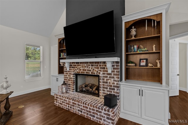 living room with vaulted ceiling, dark wood-type flooring, and a fireplace