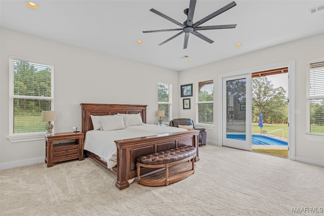 carpeted bedroom featuring ceiling fan, multiple windows, and access to exterior