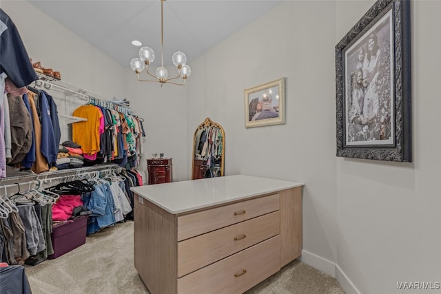 walk in closet with a chandelier and light carpet