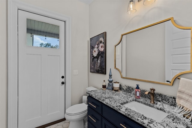 bathroom with tile patterned flooring, vanity, and toilet