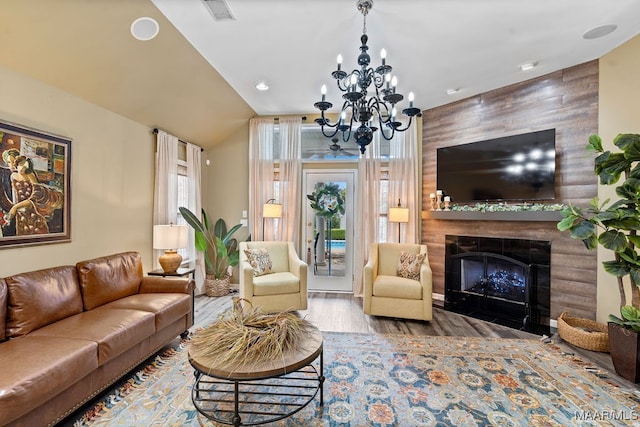 living room featuring hardwood / wood-style floors, a wealth of natural light, an inviting chandelier, and wooden walls