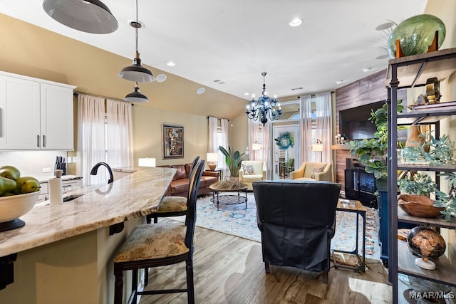 dining space featuring a wealth of natural light, hardwood / wood-style floors, and a chandelier