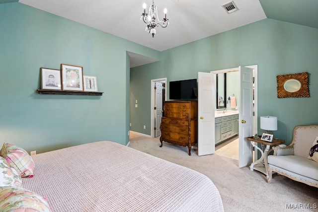 bedroom featuring a walk in closet, an inviting chandelier, lofted ceiling, ensuite bath, and light carpet