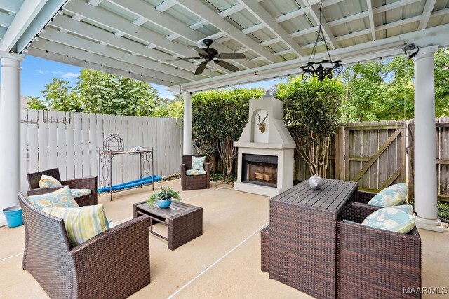 view of patio / terrace featuring ceiling fan and an outdoor living space with a fireplace