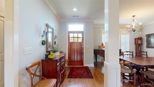 foyer entrance with a chandelier, hardwood / wood-style flooring, and crown molding