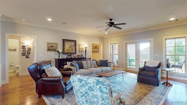 living room featuring crown molding, french doors, ceiling fan, and light wood-type flooring