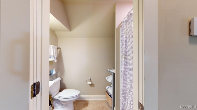 bathroom with tile patterned flooring, lofted ceiling, and toilet