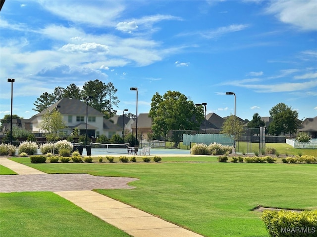 surrounding community featuring a yard and tennis court