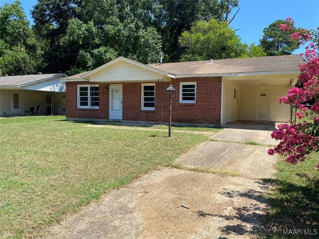 ranch-style home with a front lawn and a carport