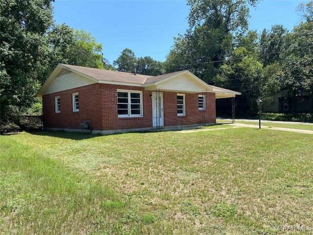 ranch-style home featuring an attached carport, brick siding, and a front lawn