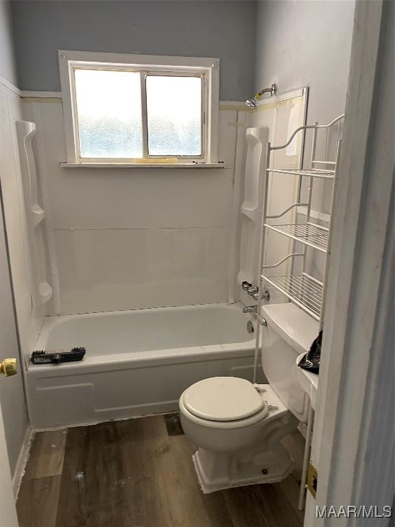 full bathroom with toilet, wood finished floors, and shower / bathtub combination