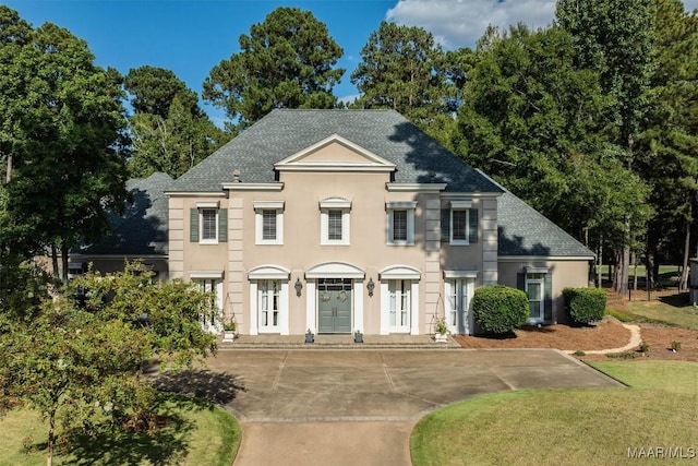 view of front of home with a shingled roof and stucco siding