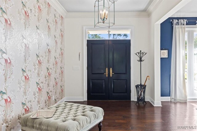 entryway featuring crown molding, dark hardwood / wood-style flooring, and an inviting chandelier