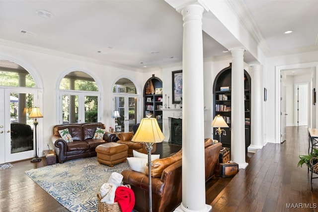 living room with built in shelves, dark hardwood / wood-style flooring, french doors, and ornate columns